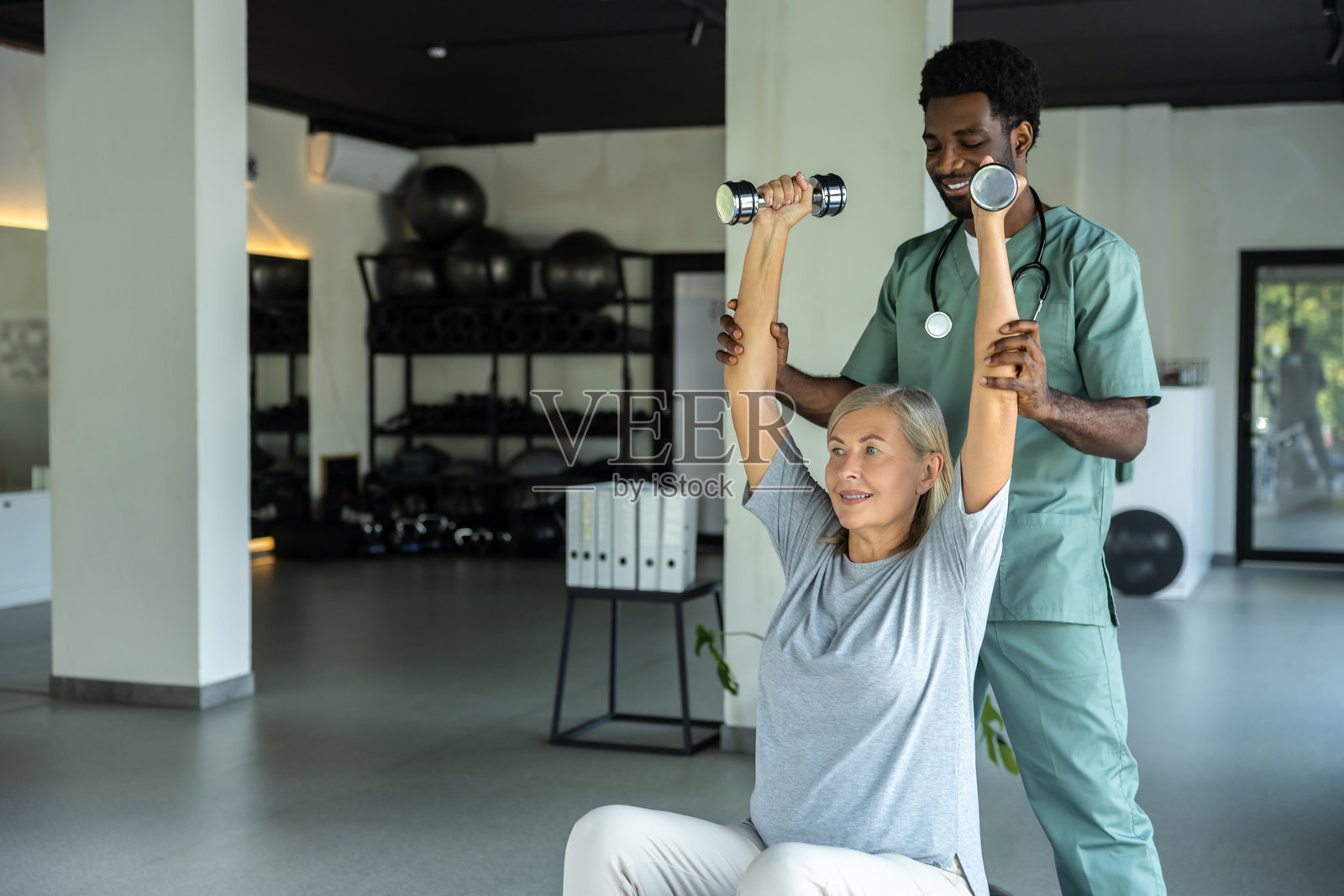 男性物理治疗师在诊所中使用物理治疗技术与患者合作照片摄影图片