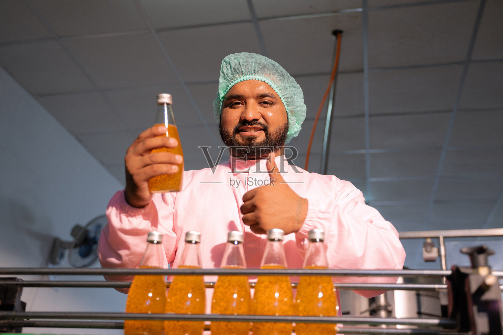 员工在饮料工厂工作。照片摄影图片