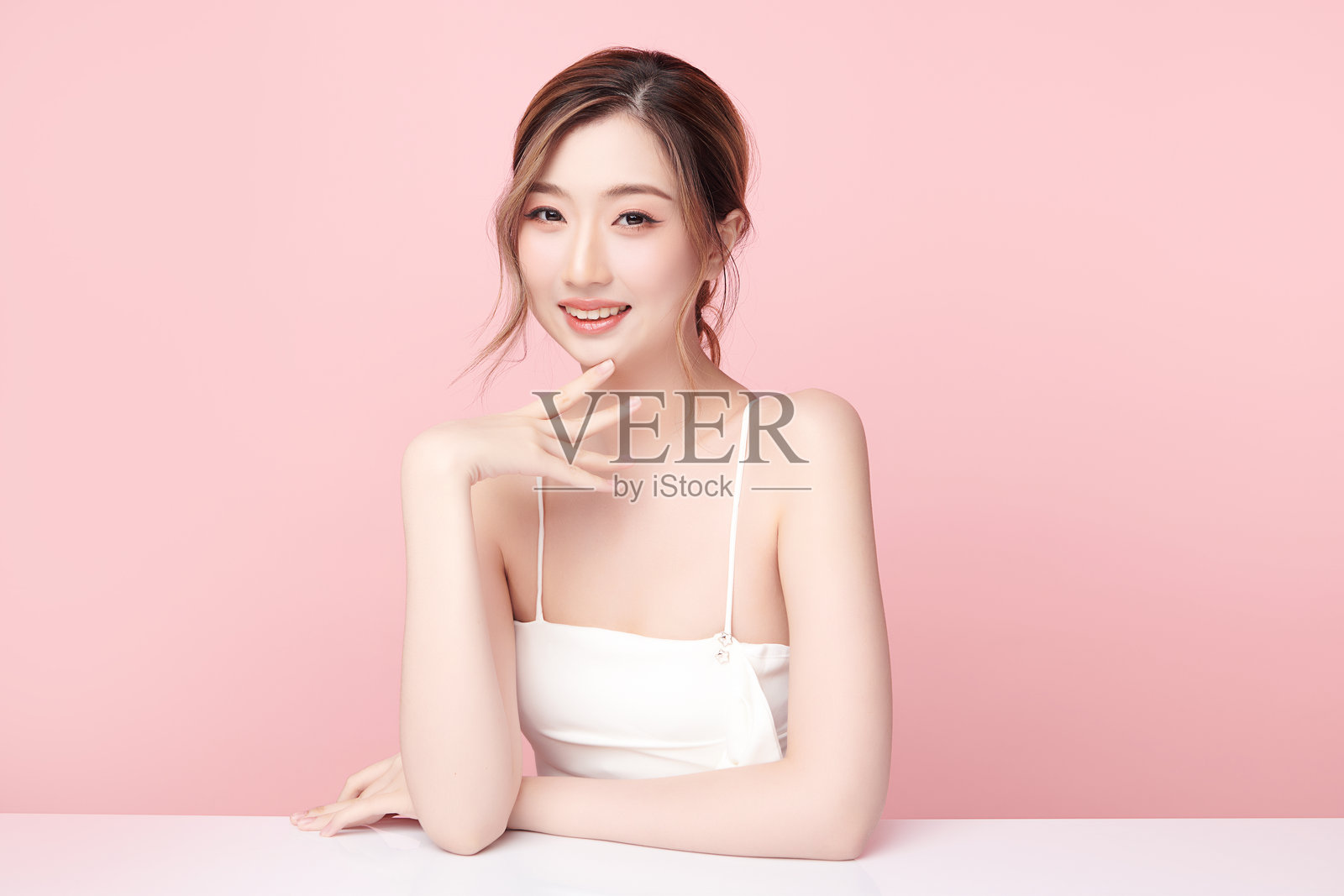 美丽的年轻亚洲女性干净新鲜的皮肤在粉红色的背景，面部护理，面部护理，美容，美容和水疗，亚洲女性肖像。照片摄影图片