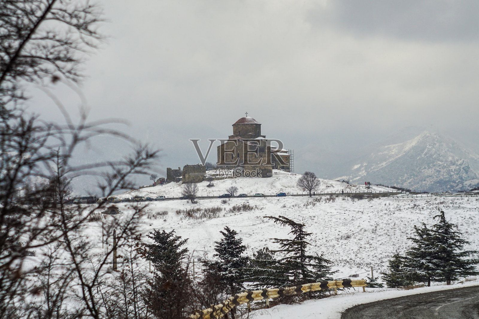 在雪雾天气下的贾尔维修道院。可以看到飘落的雪和覆盖着雪的田野。照片摄影图片