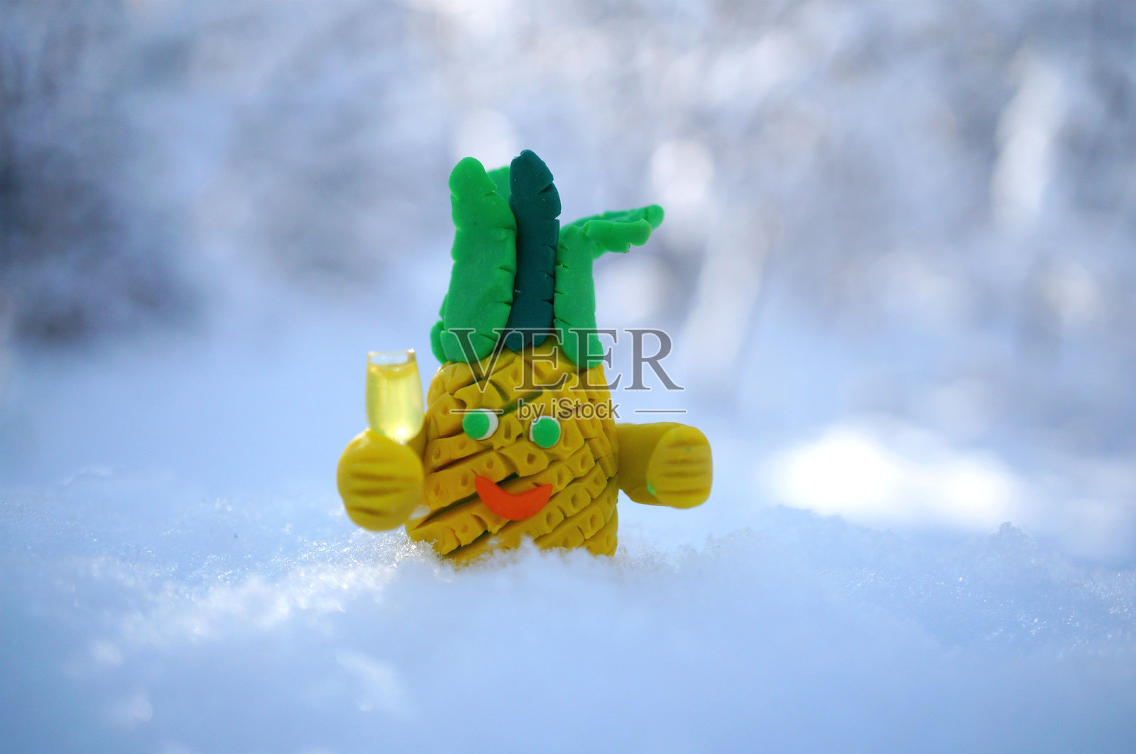 玩具菠萝与一杯香槟。用塑料泥制作的搞笑人物。照片摄影图片