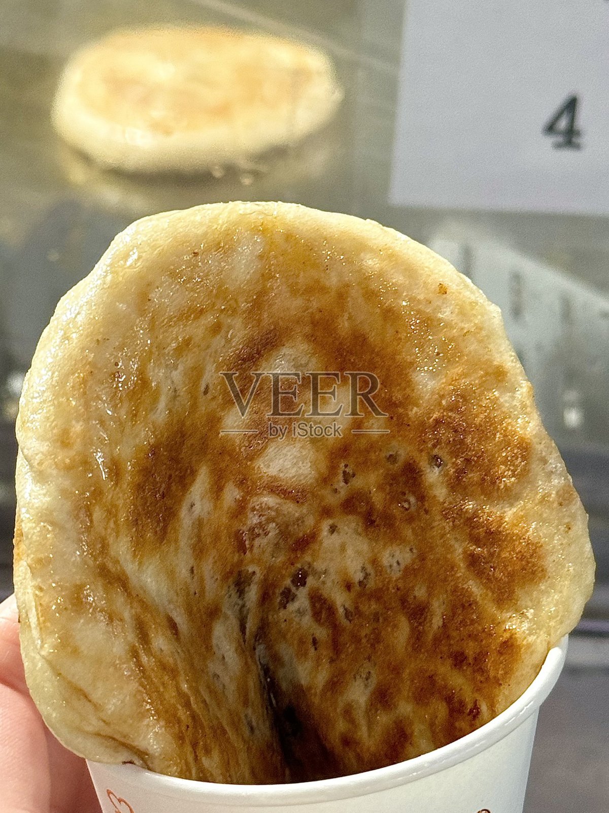 热糖饼，韩式糖浆煎饼：发酵面团制成球状，内填一勺红糖，然后在预热的平底锅中煎炸。照片摄影图片