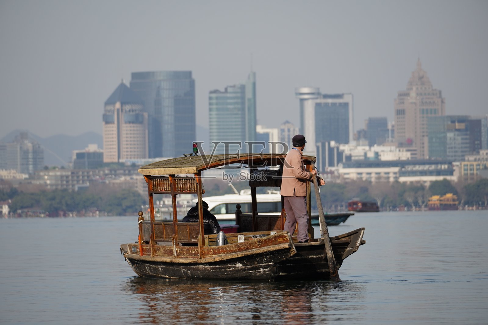 男子在城市景观中划船照片摄影图片