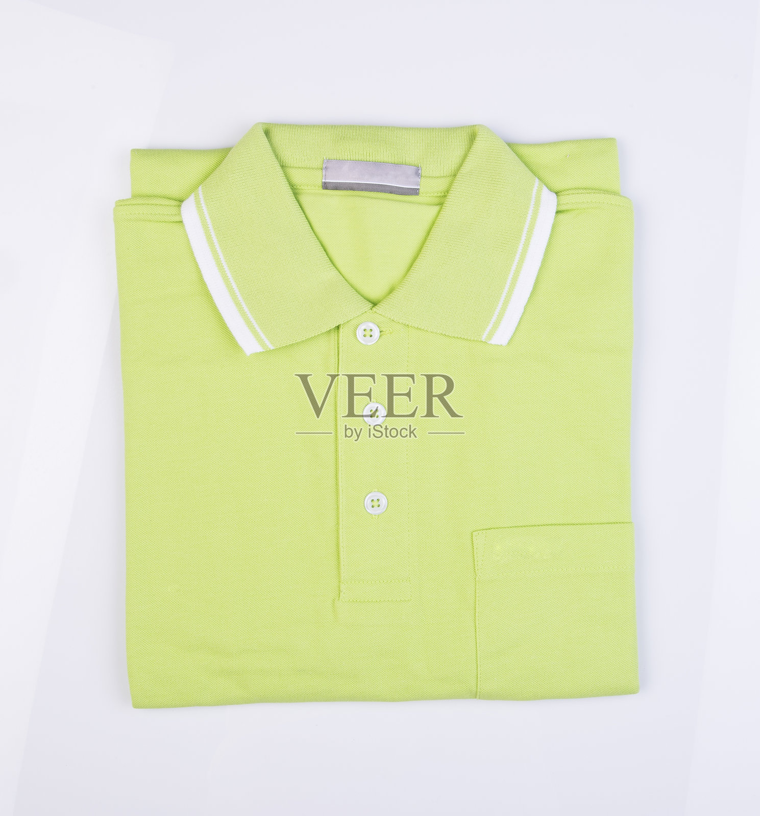 绿色T恤在白色背景上折叠的特写镜头照片摄影图片