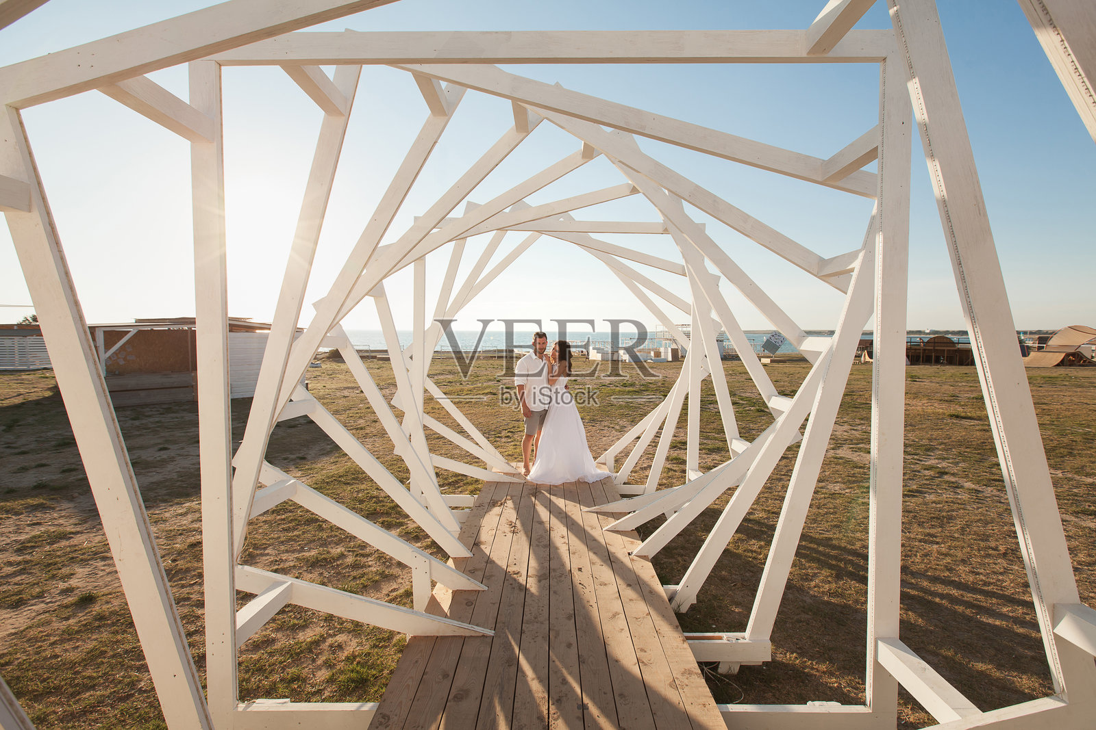 男女模特摆姿势。几何木结构。新郎和新娘。照片摄影图片