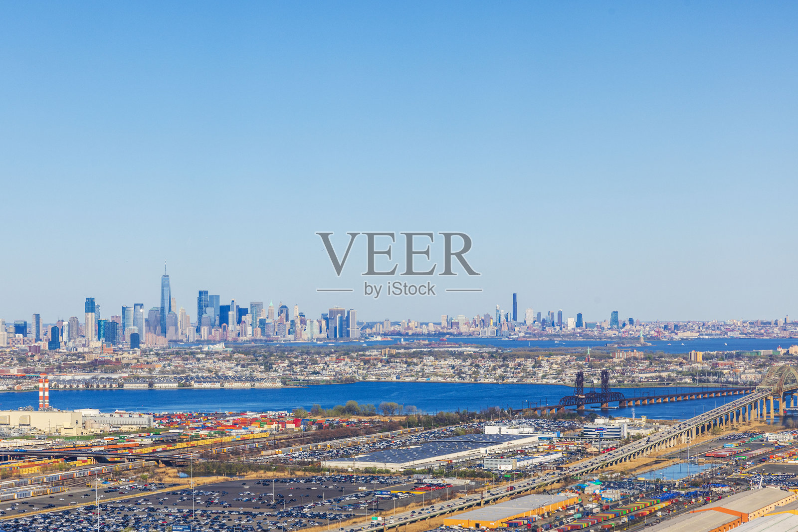 曼哈顿天际线的全景，背景是哈德逊河、工业区和桥梁，蓝天晴朗。美国。照片摄影图片
