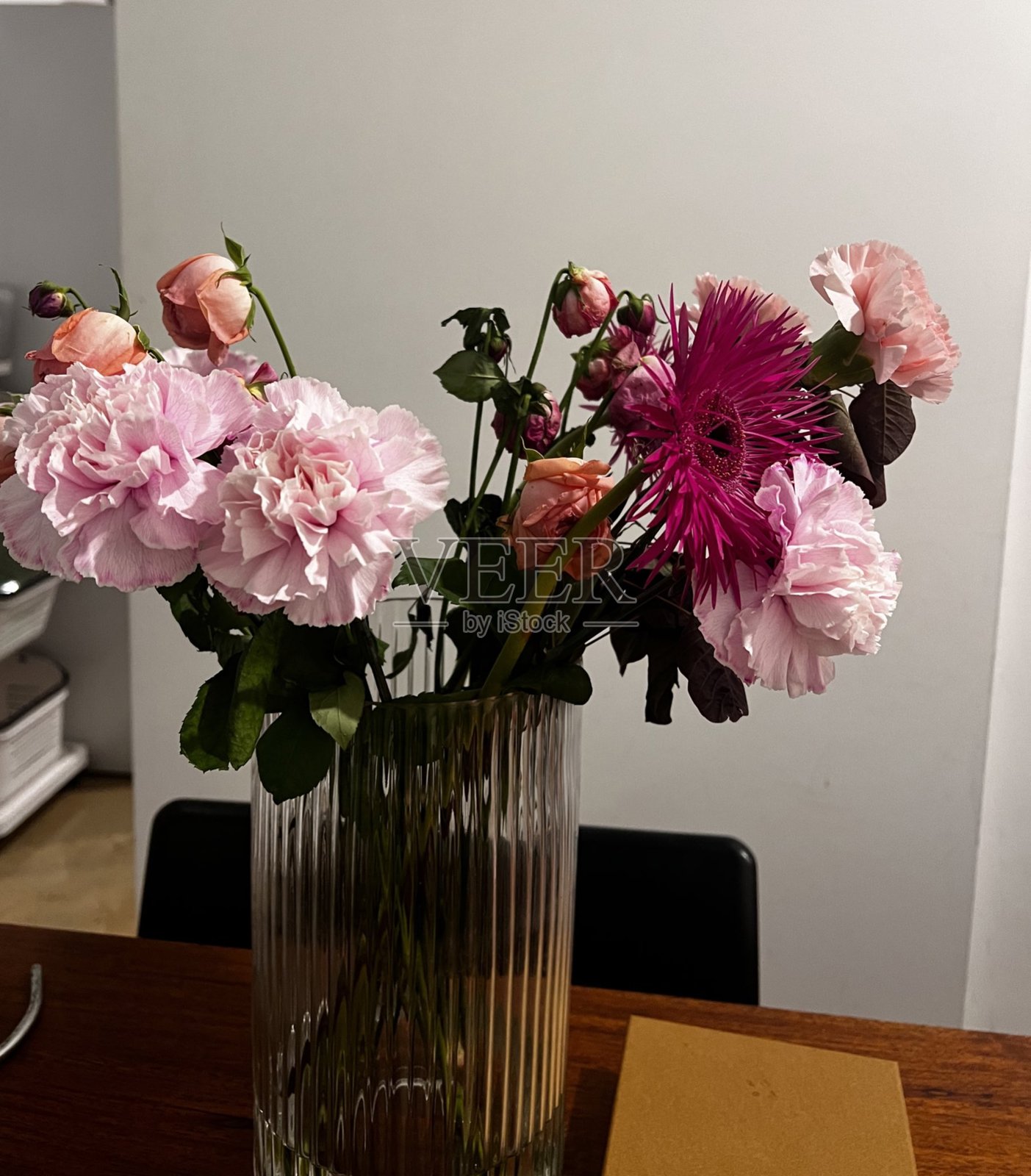 一束色彩斑斓的新鲜花卉，精美地排列以突出它们的自然美。非常适合庆祝特殊场合或为任何空间增添亮丽。照片摄影图片