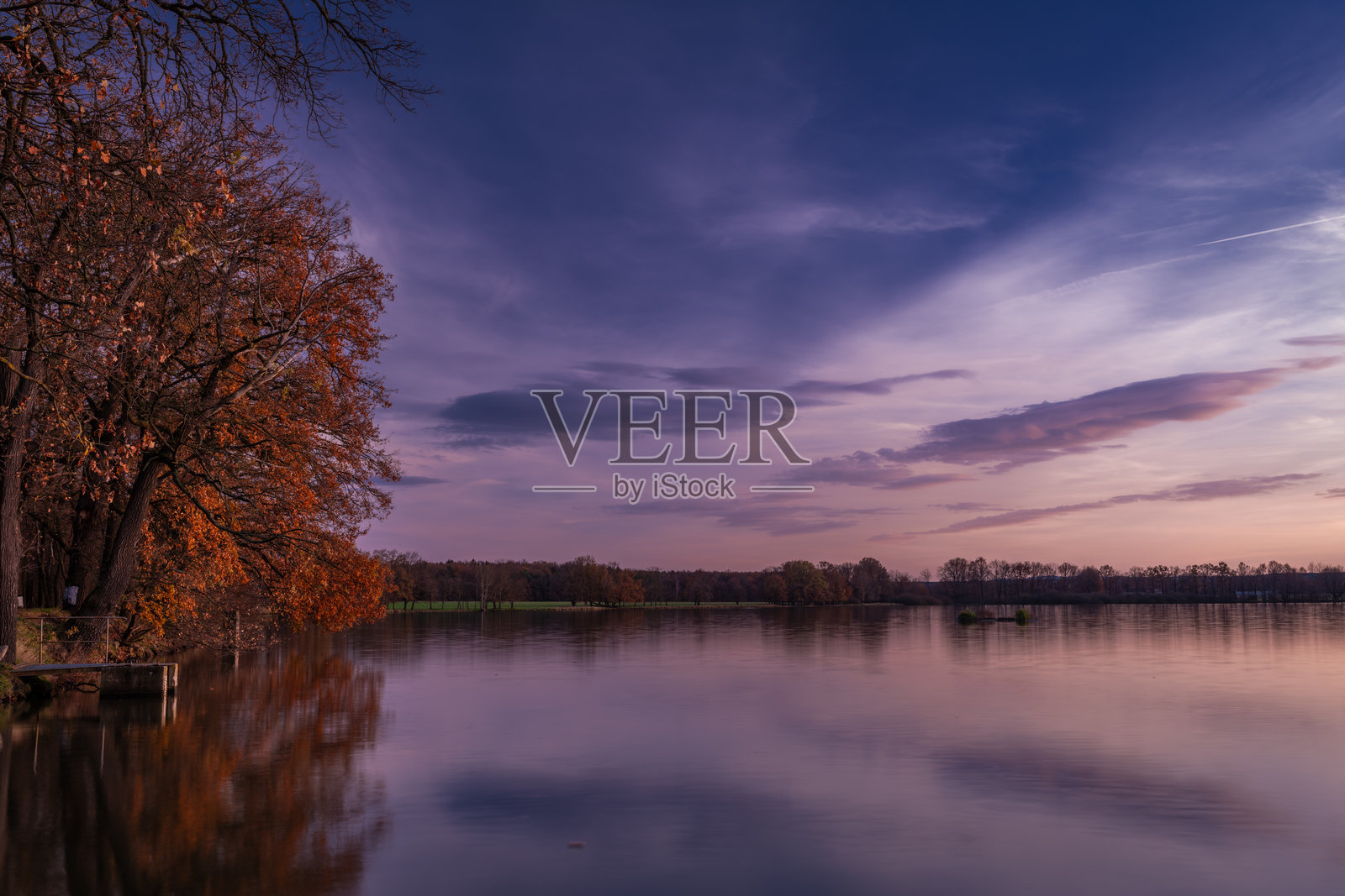 秋天阳光明媚的傍晚，维萨托夫湖映照着夕阳的色彩光芒照片摄影图片