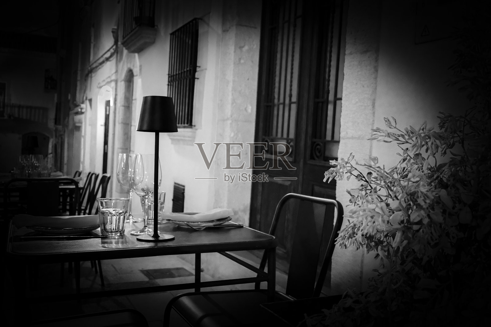 户外街头露台餐厅桌子，单人座位，酒杯，盘子，黑白氛围照片摄影图片
