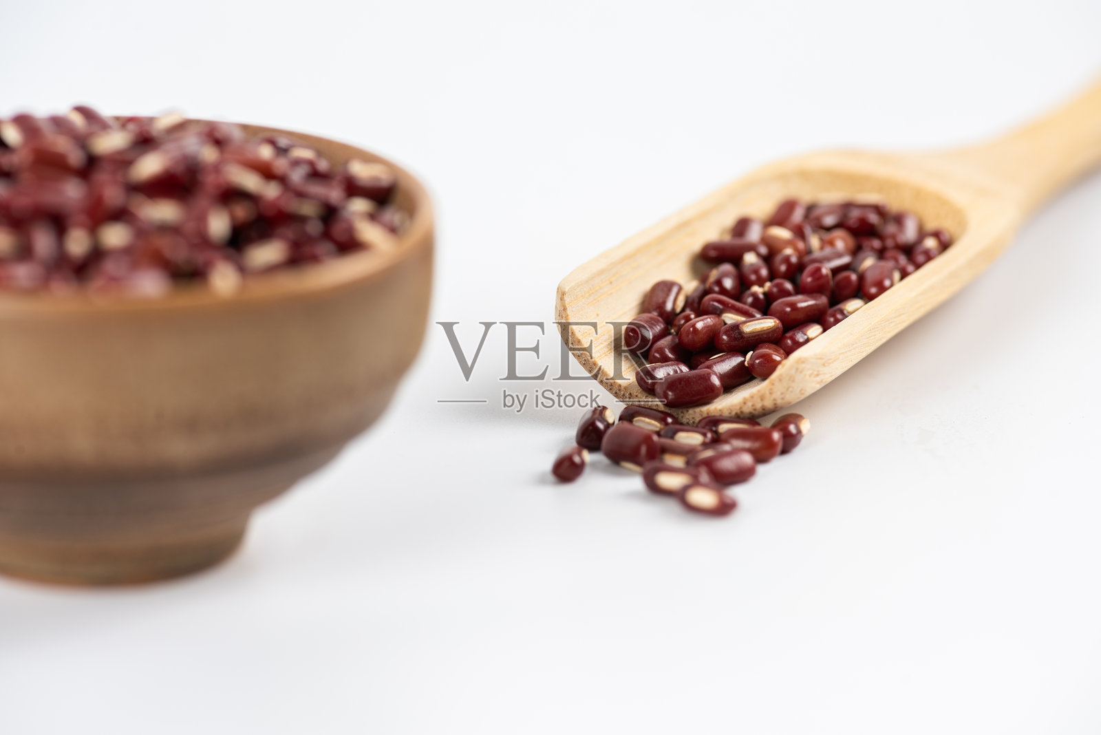 白色背景上的木勺里的红豆照片摄影图片