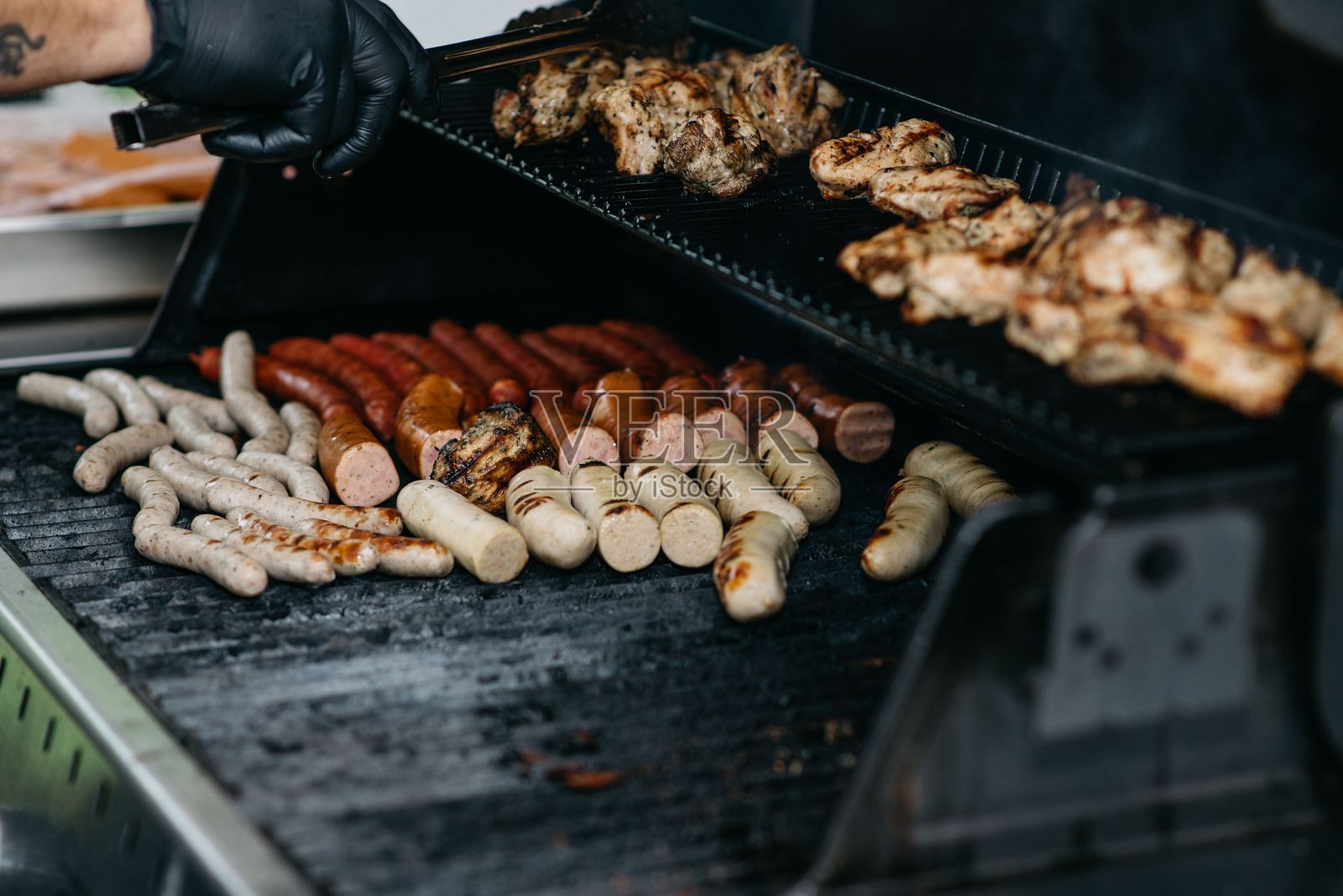 各种肉类在烧烤架上烤制。照片摄影图片