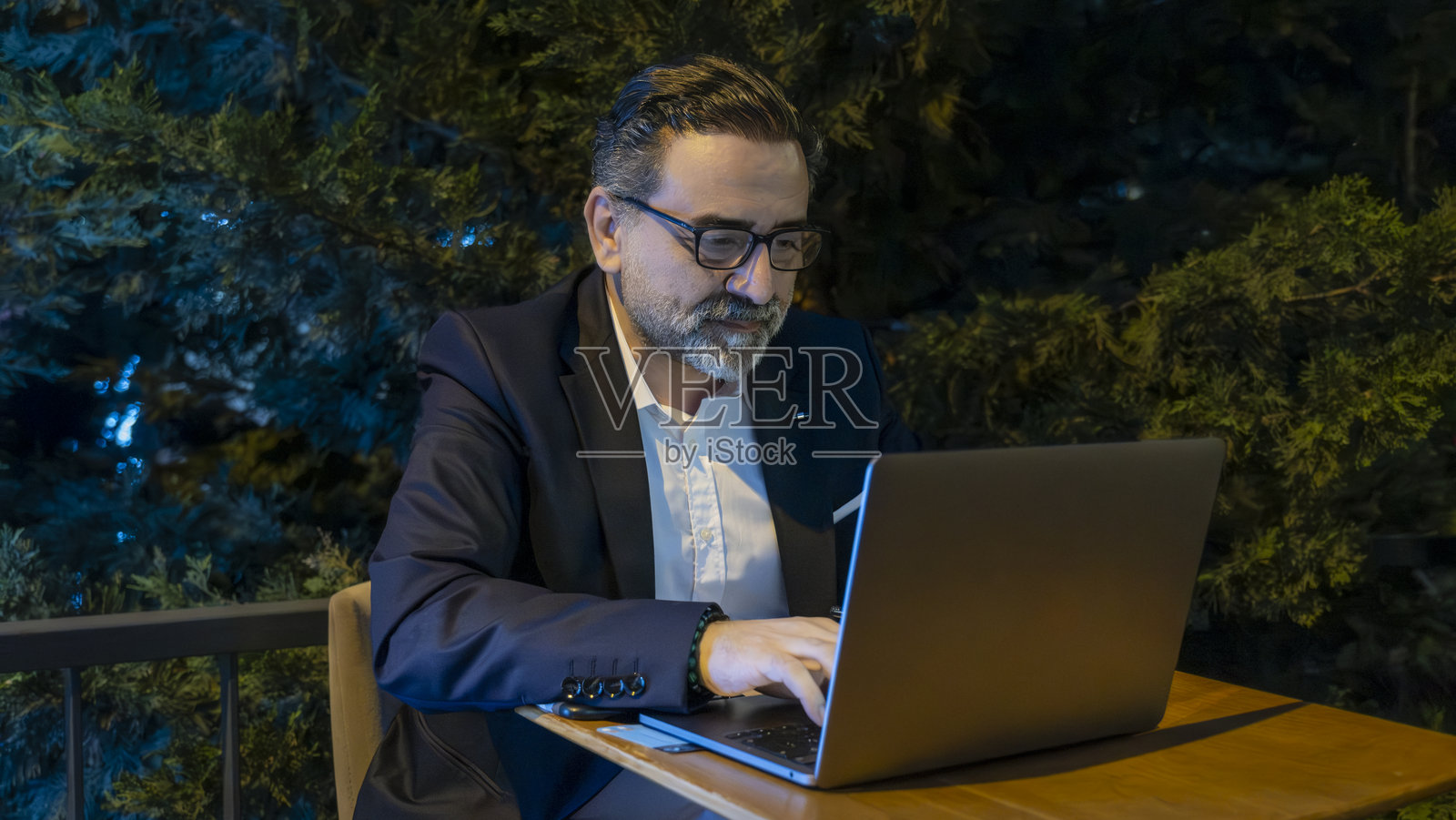 成熟英俊的商人在办公室外用笔记本电脑工作照片摄影图片