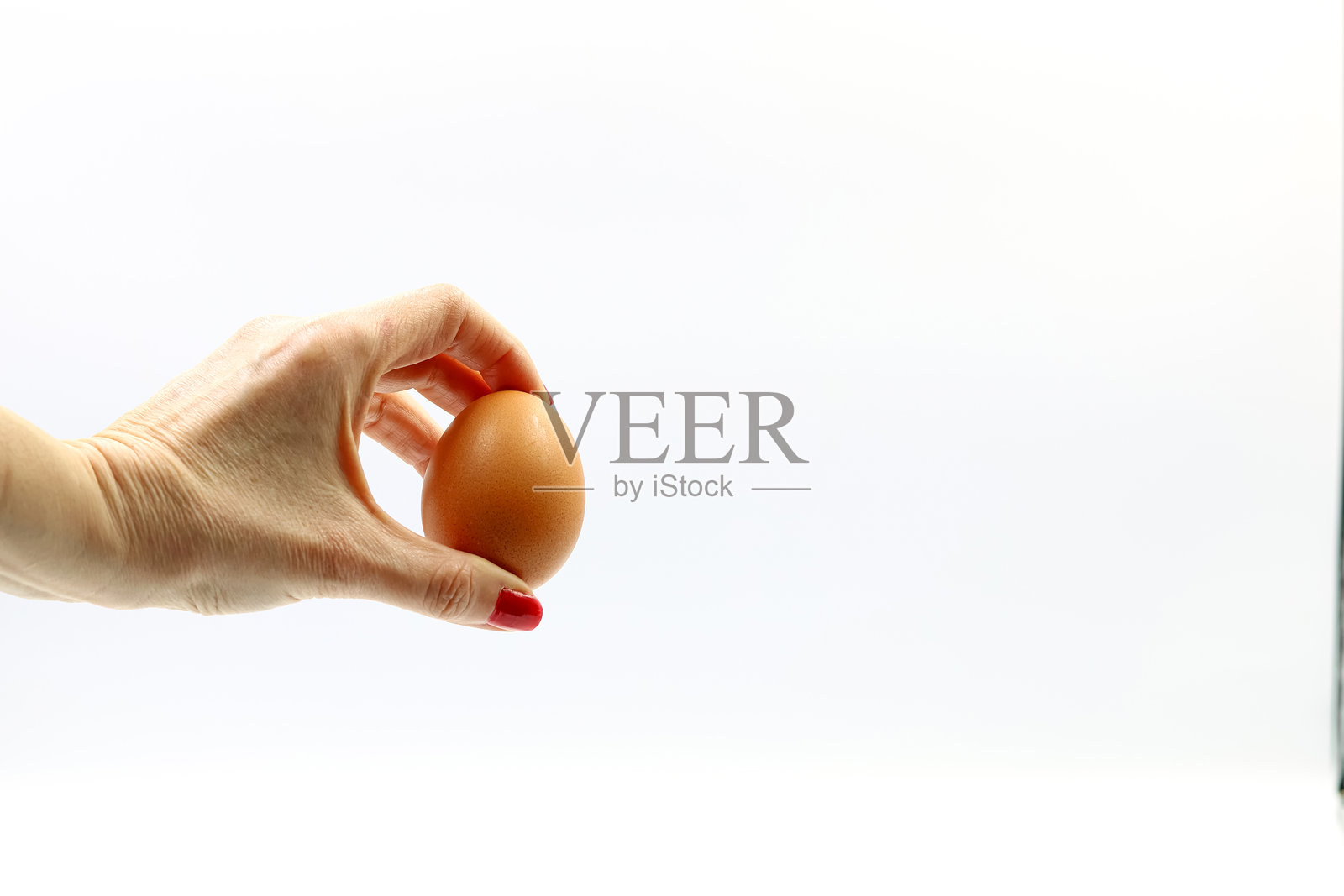 女人的手握着一个鸡蛋。留有文字空间。照片摄影图片