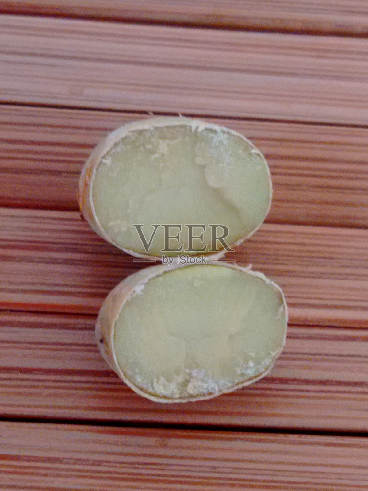 切开的皮唐果种子：内部结构及木板背景细节。照片摄影图片