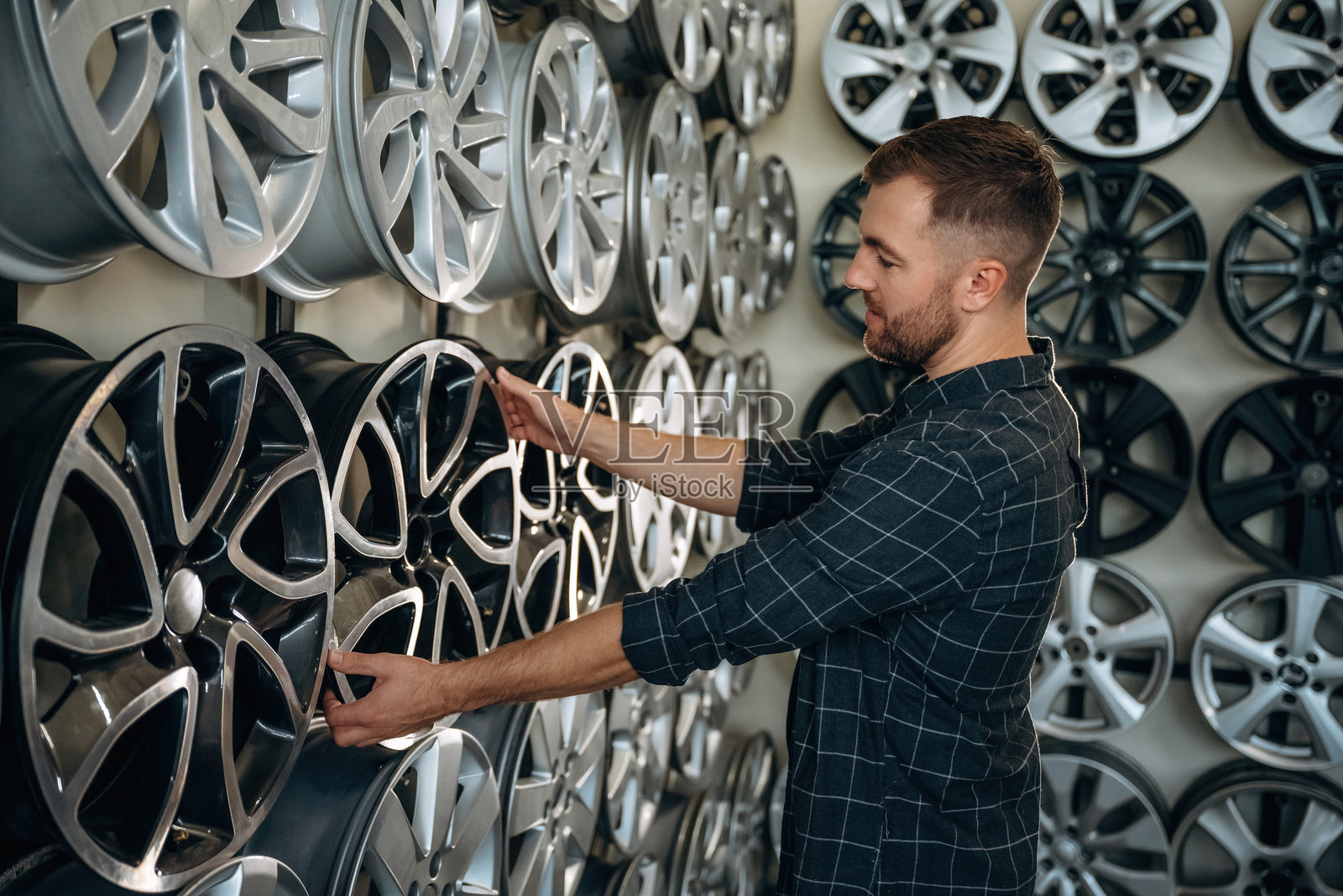 选择合适的轮胎。工人在维修站处理轮胎和车轮。照片摄影图片