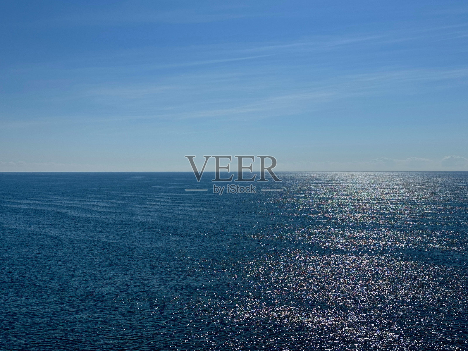 开阔的海洋蓝色闪亮水面与阳光明媚的天空地平线照片摄影图片