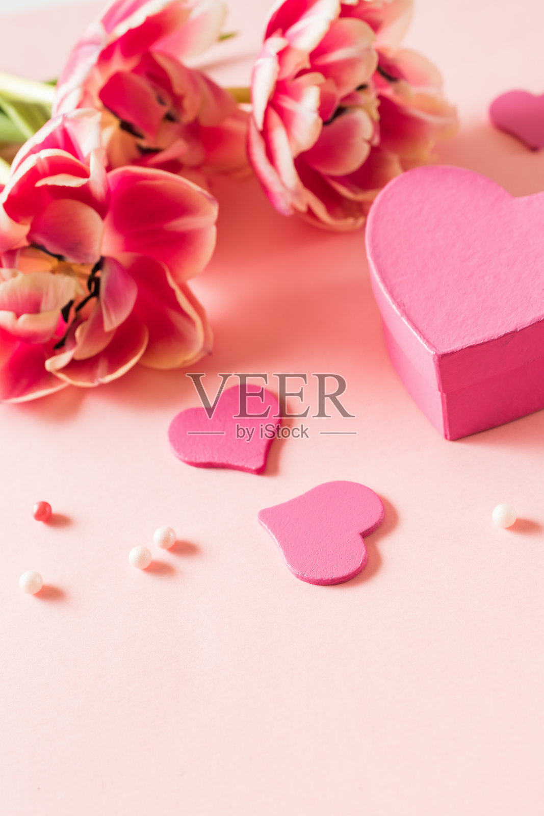 粉色郁金香和心形图案在浅粉色背景上照片摄影图片