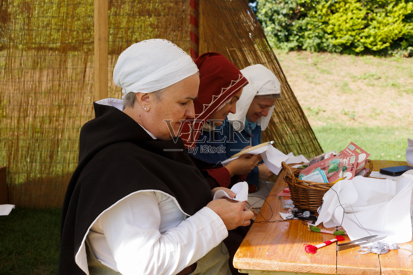 身穿中世纪服装的女性在历史重演活动中刺绣，曼托瓦照片摄影图片