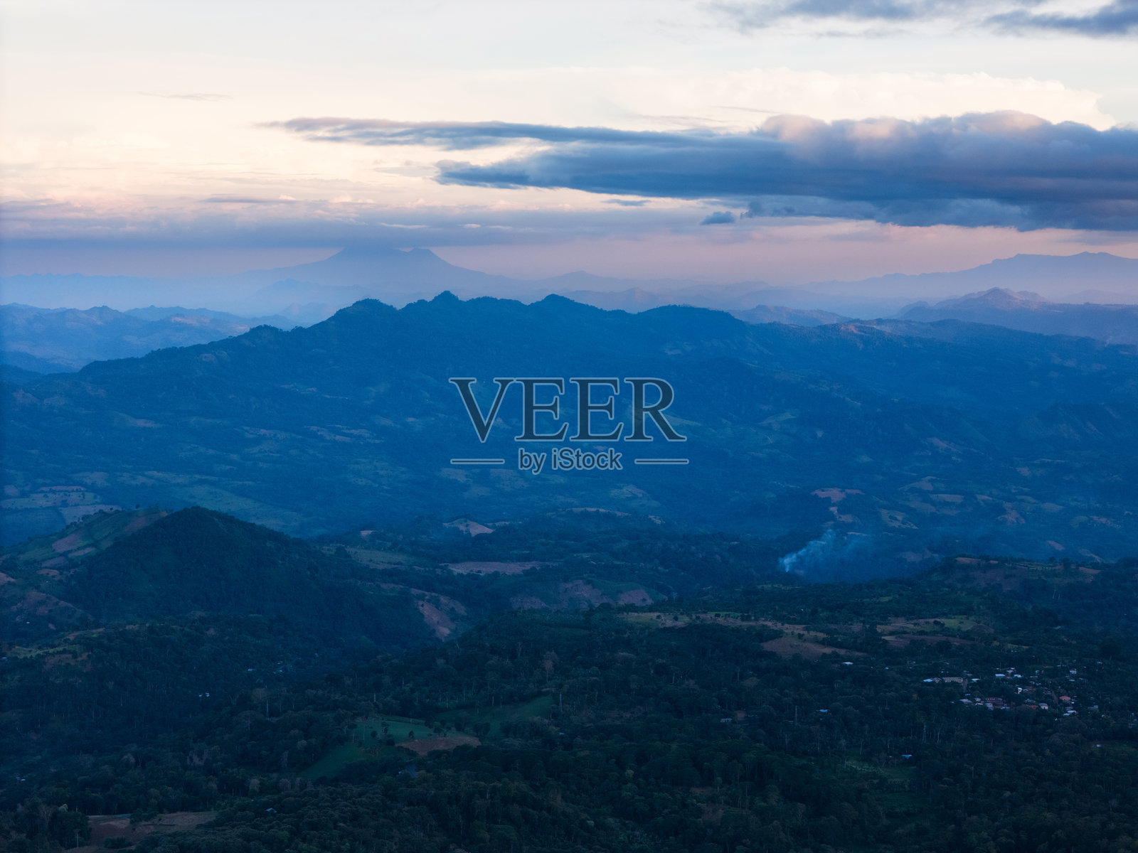 黄昏时分的山地风景，远处的山峰与柔和多彩的天空照片摄影图片