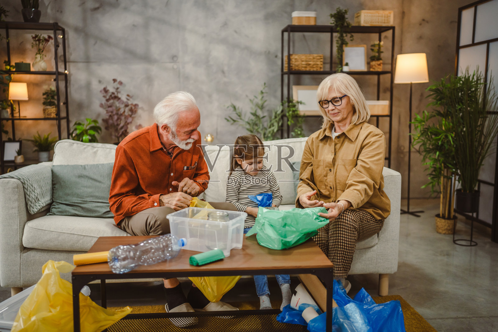 祖父母与孙子一起在塑料袋中进行回收活动照片摄影图片