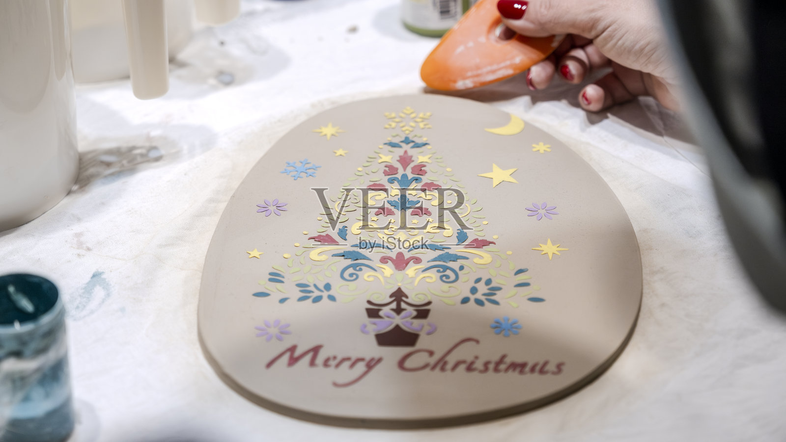 在工作室艺术活动中制作的印有圣诞主题图案的陶土盘子照片摄影图片