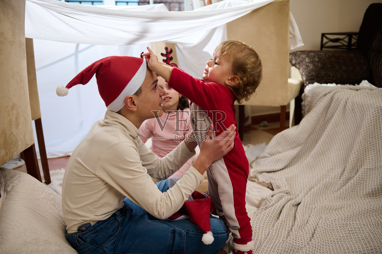 家庭与孩子们一起享受圣诞传统，搭建温馨的毯子堡垒照片摄影图片