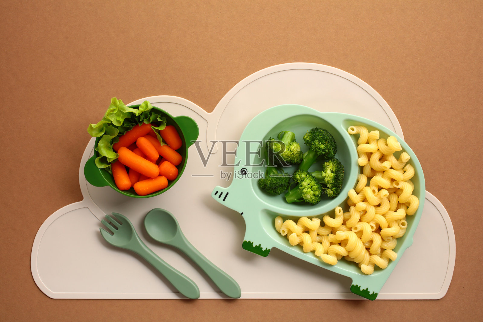 大象形状的儿童餐盘，配有健康食品选项，如西兰花、意大利面和胡萝卜。非常适合促进儿童享受有趣和营养的餐食。照片摄影图片