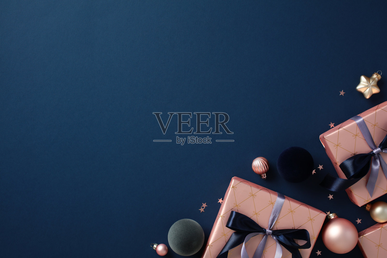 优雅的圣诞礼物，配有蓝色丝带和装饰品，背景为深蓝色，非常适合节日季节的营销和假日设计。照片摄影图片