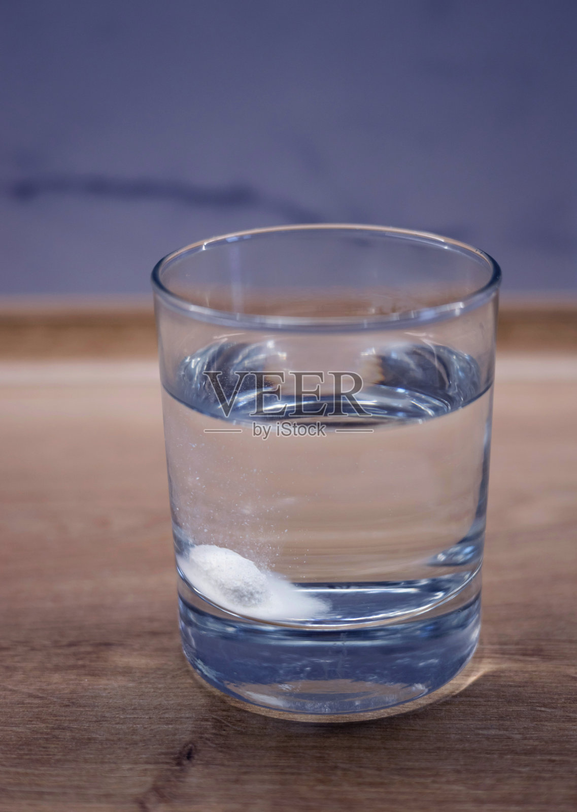 药片迅速溶解在一杯水中。照片摄影图片