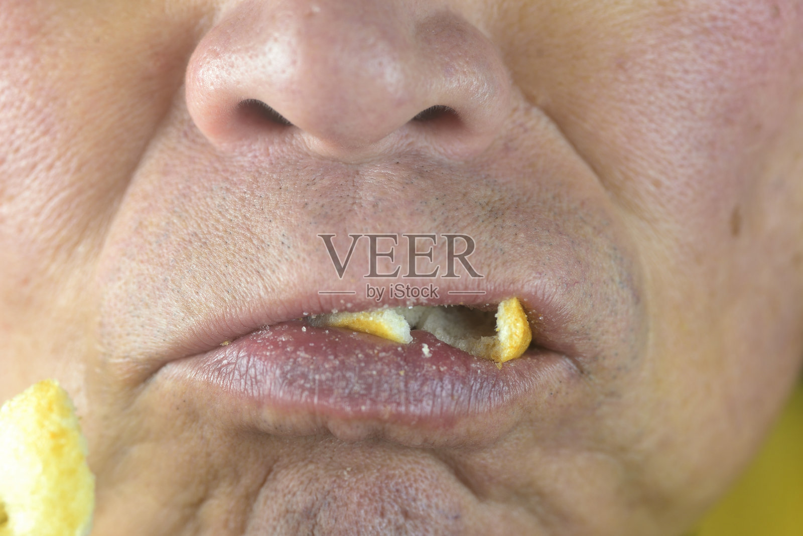 一位健康的老年人正在吃硬米饼照片摄影图片