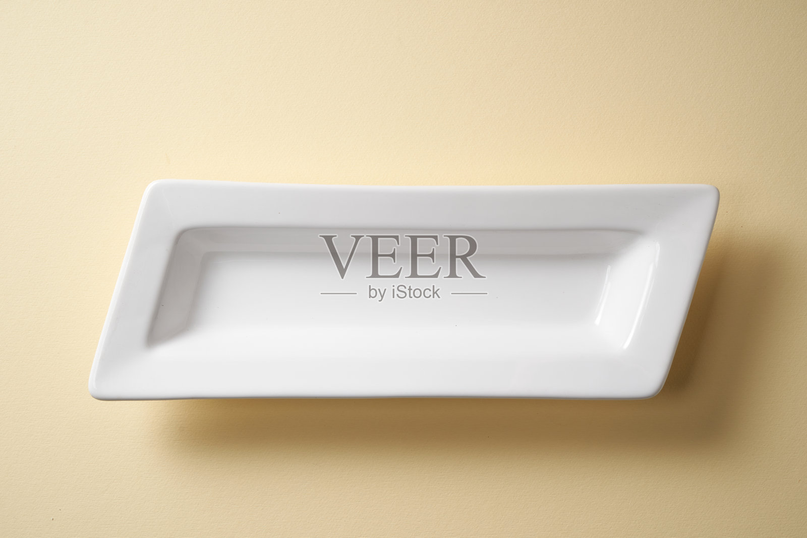 空的矩形晚餐上菜盘，背景为黄色照片摄影图片