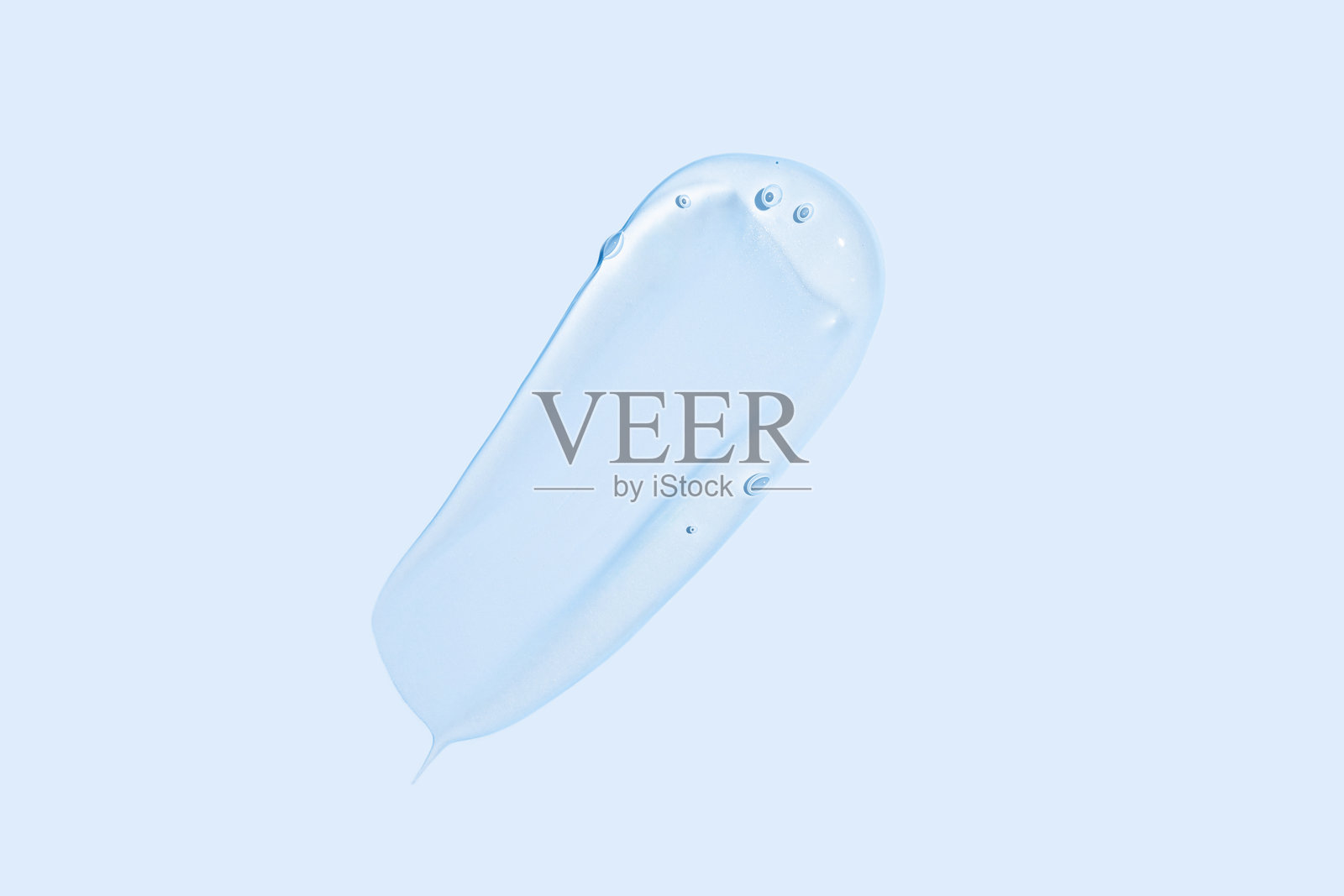 蓝色液体化妆凝胶或精华的特写，带有光滑闪亮的质感，背景为平滑的蓝色。照片摄影图片