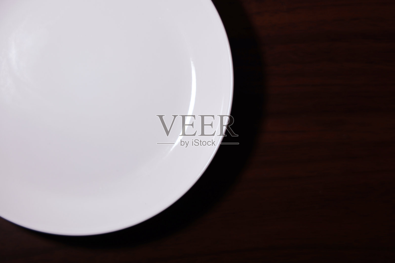 空白的白色盘子放在木桌上。照片摄影图片