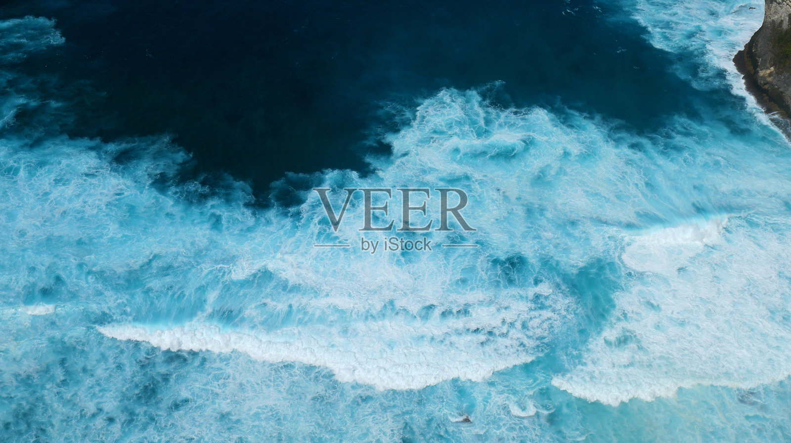 黑暗海洋背景的海景，波浪拍打岩石。热带海滩的夏季海边户外。水面蓝色波浪图案。绿松石色海水与深蓝色海洋的白色波浪图案。照片摄影图片