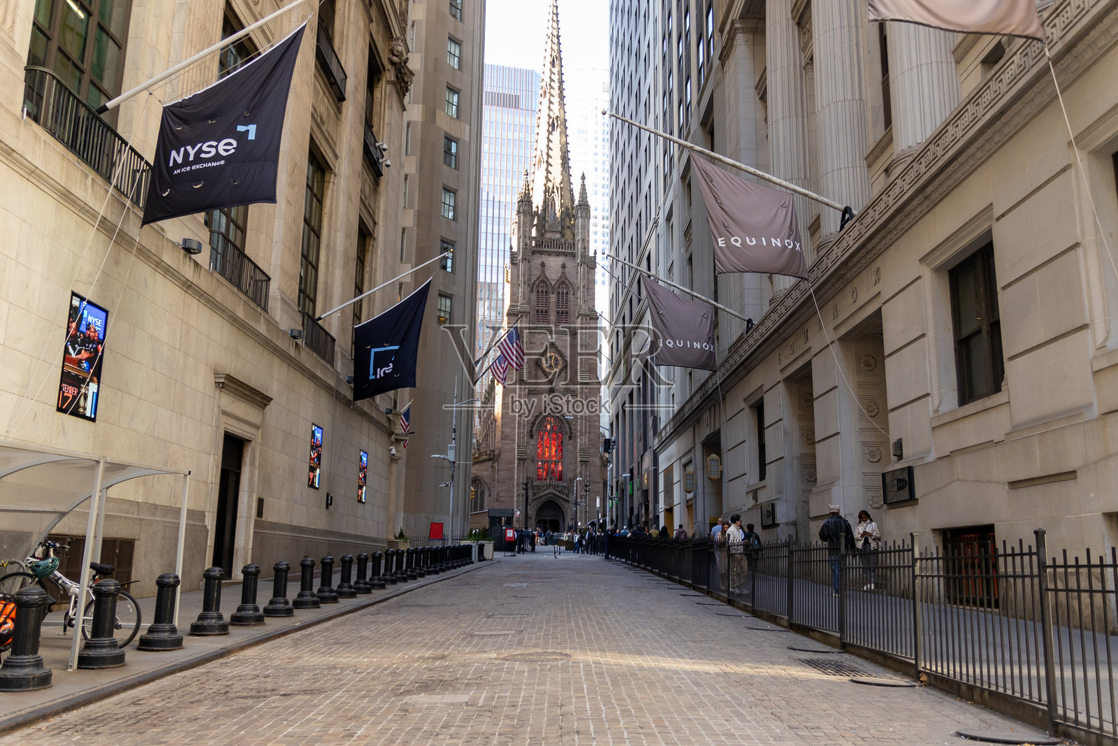 繁忙的行人场景，背景是热闹的华尔街和三位一体教堂。照片摄影图片