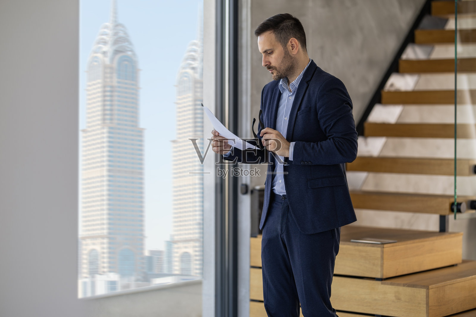 商人在现代办公室环境中审阅文件照片摄影图片