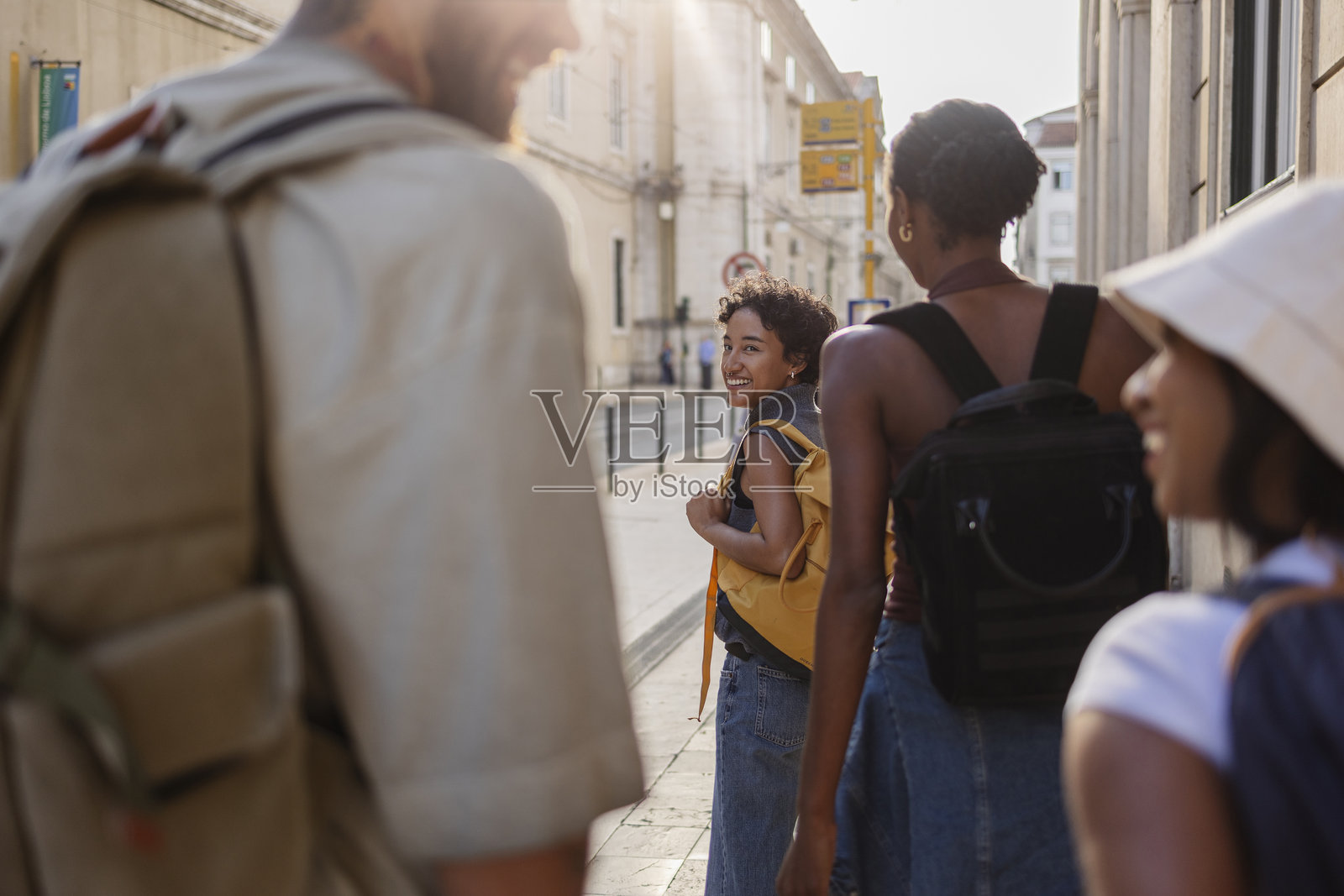 四个快乐的年轻背包客正在里斯本的拉夫拉缆车轨道上行走，享受他们的假期并探索这座城市。照片摄影图片