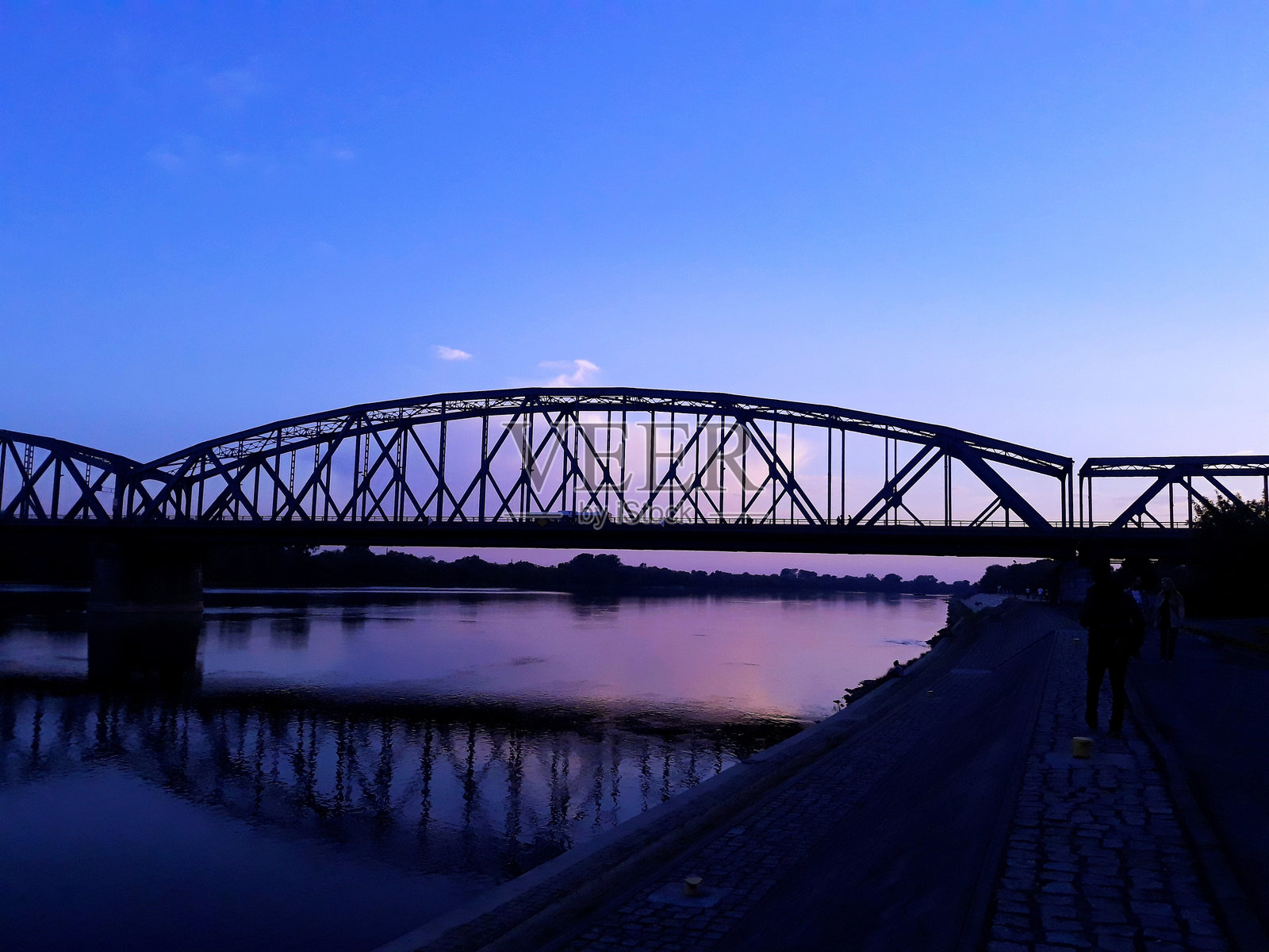黄昏时分蓝天映衬下的河上桥梁照片摄影图片