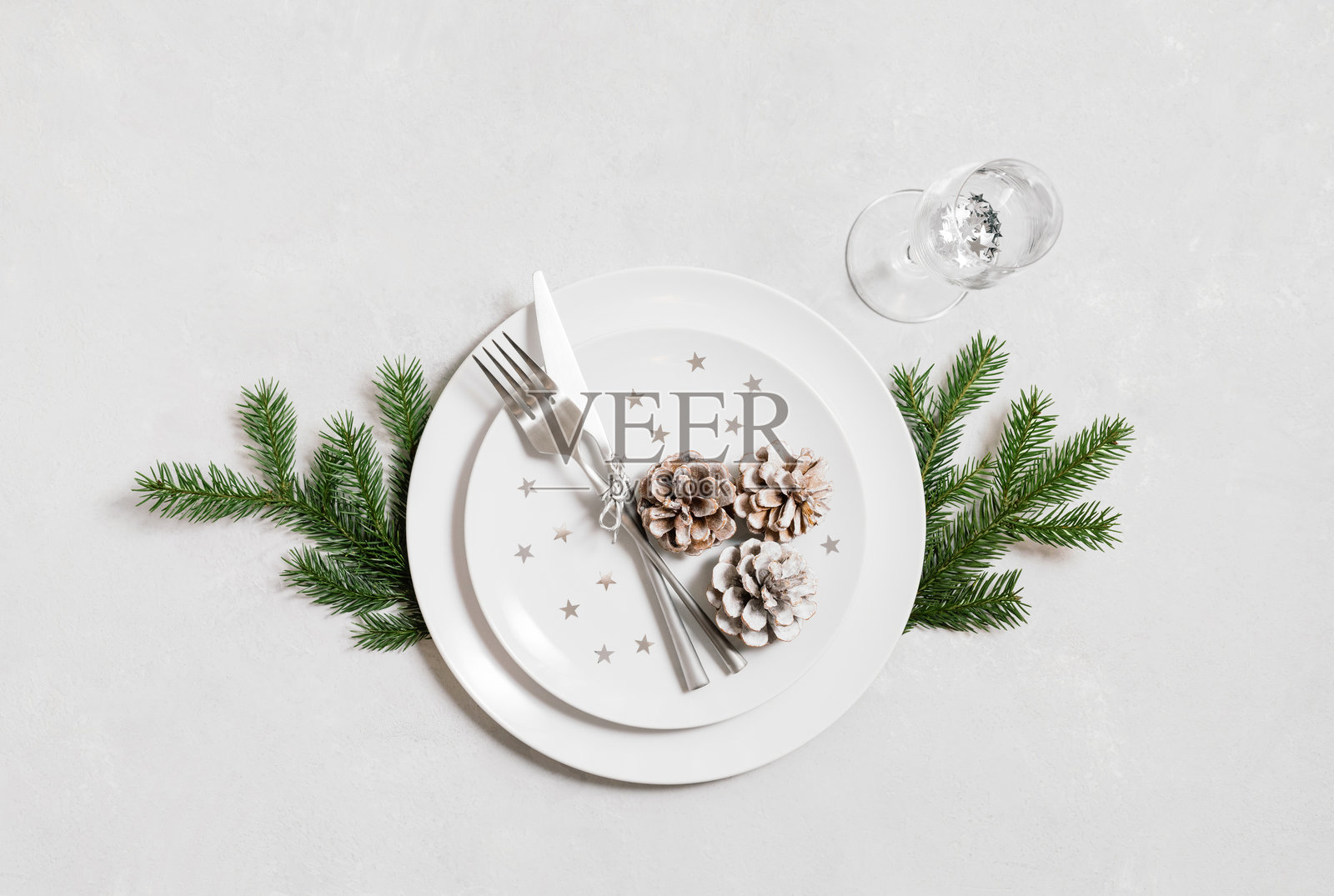 圣诞晚餐的节日餐桌布置，银色餐具搭配白色背景。俯视角度。照片摄影图片