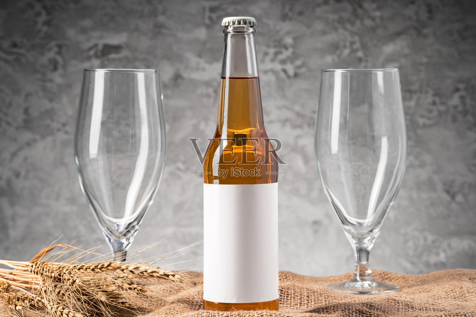 啤酒瓶和啤酒杯在灰色背景下照片摄影图片