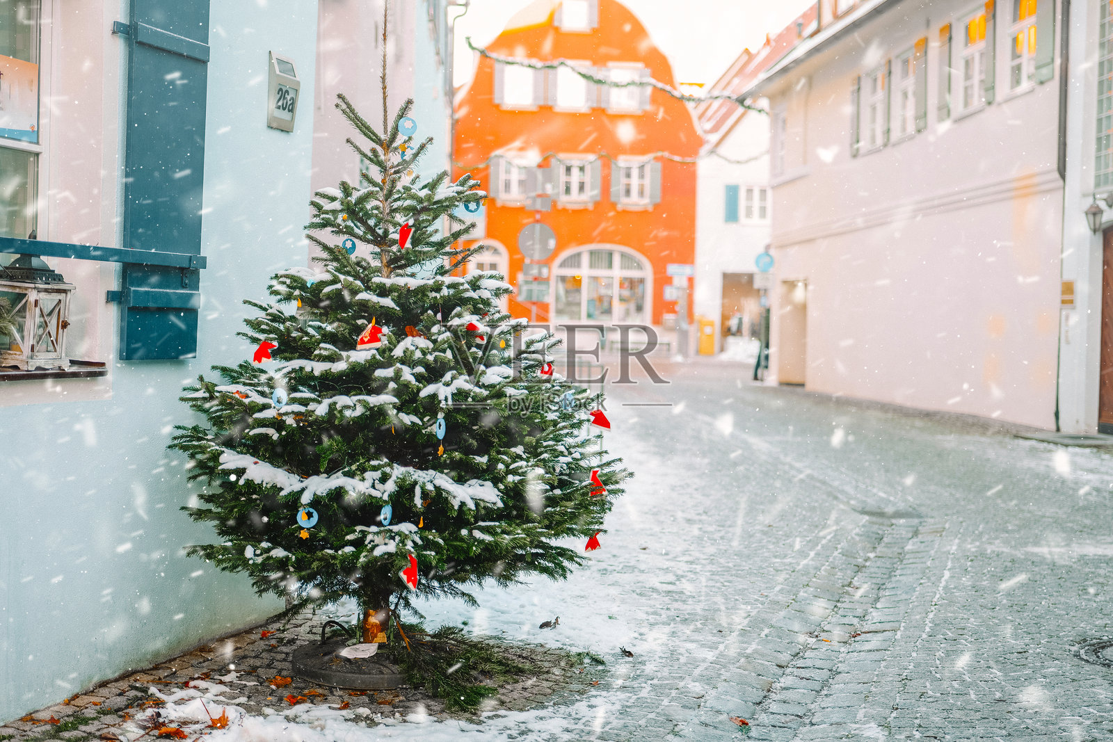 圣诞雪镇，圣诞树和飘落的雪花。圣诞街道树和飘落的雪花。冬季假日背景。德国城市中的圣诞氛围。照片摄影图片