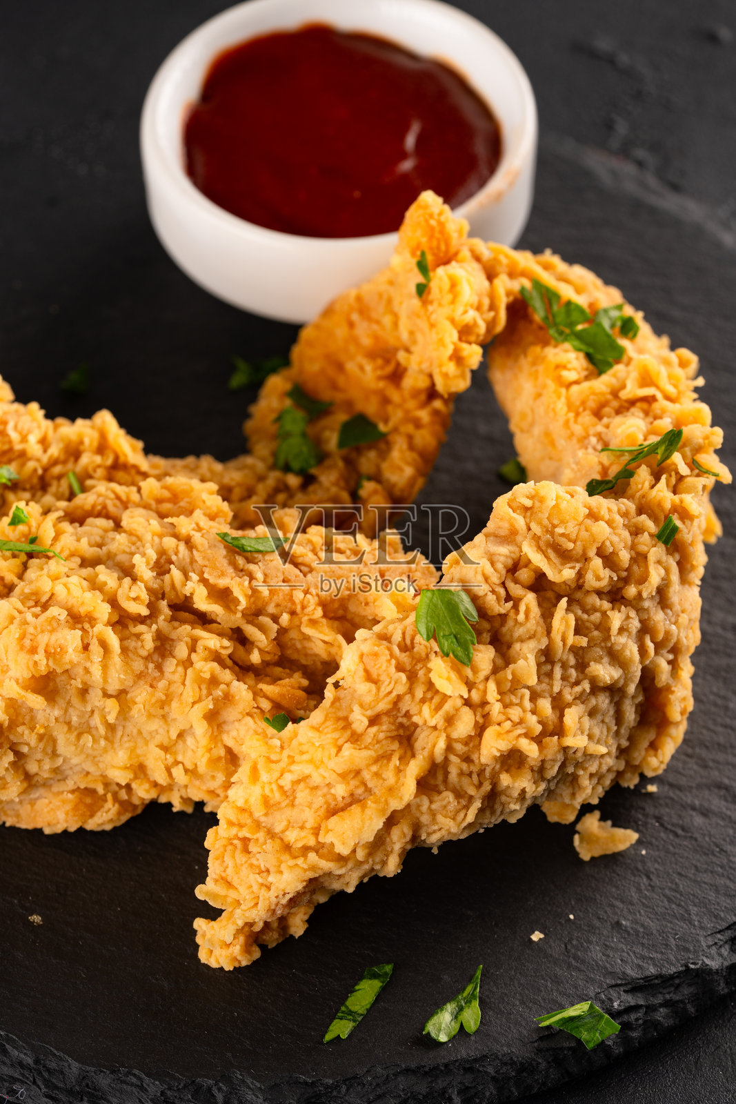 黑色背景上的炸鸡胸肉条。鸡肉脆片照片摄影图片