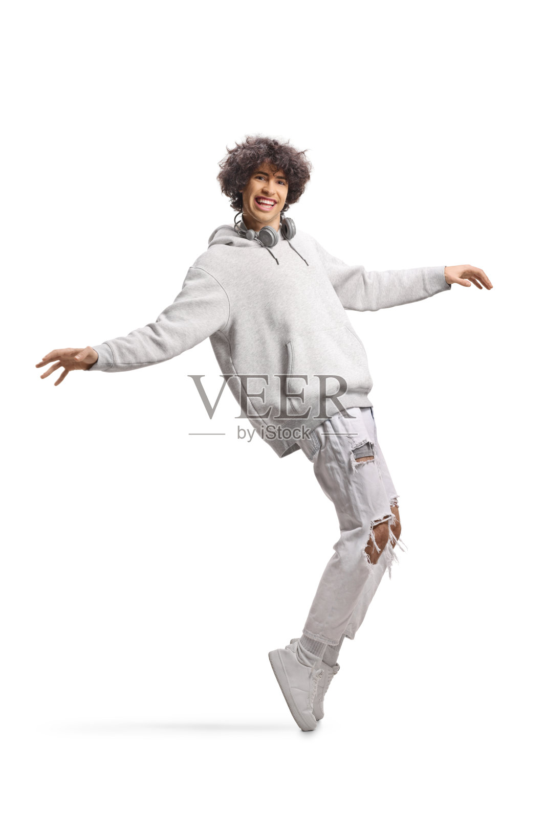 戴着耳机的男孩在跳舞并微笑照片摄影图片