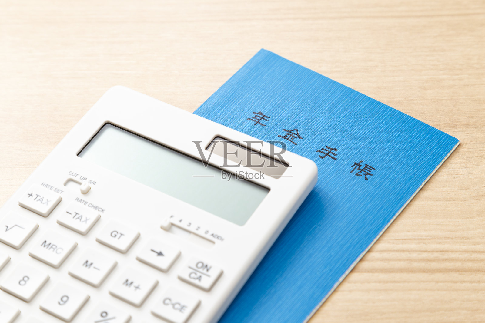 桌子上的计算器和养老金手册照片摄影图片