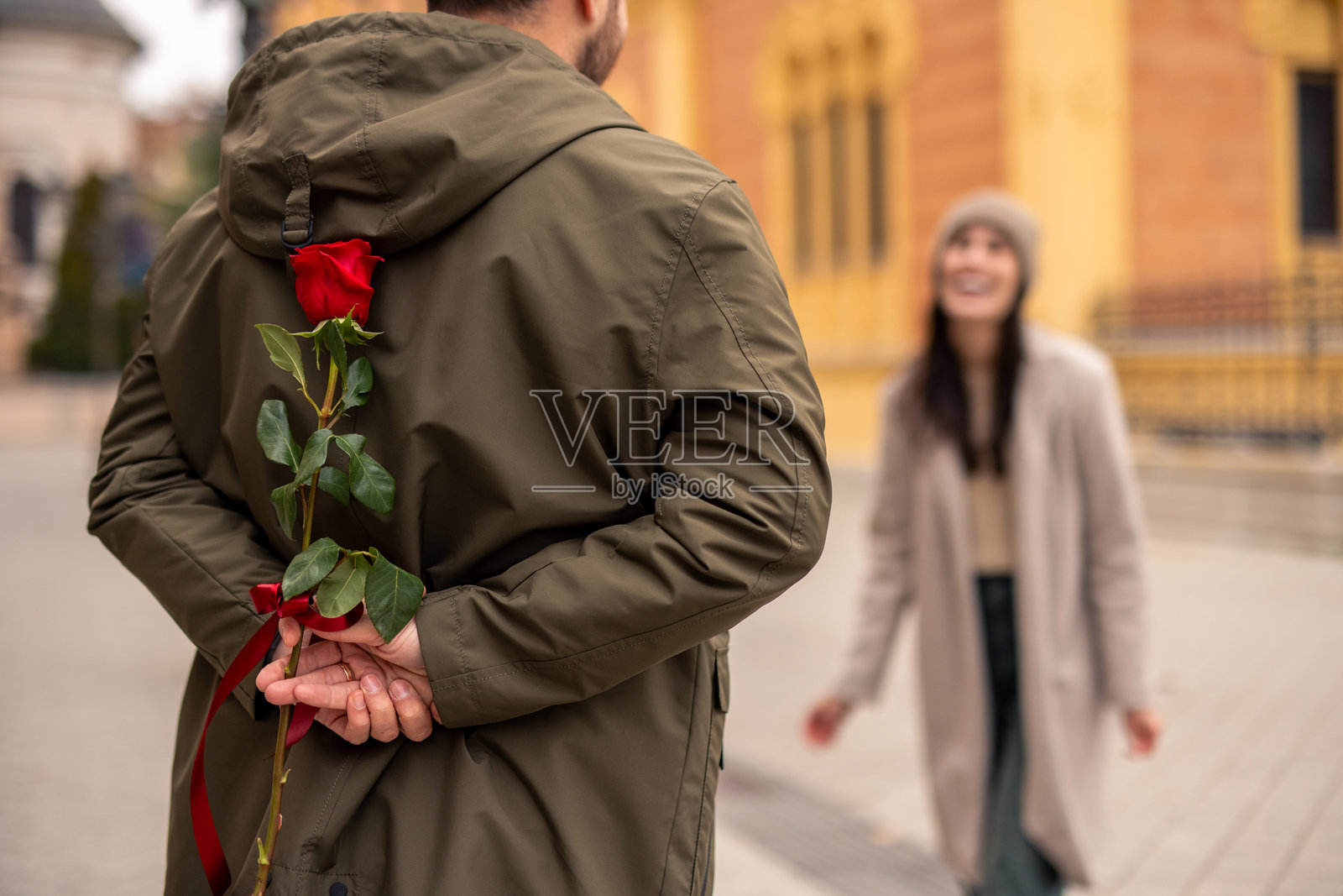 白人男性用藏起来的玫瑰给妻子惊喜照片摄影图片