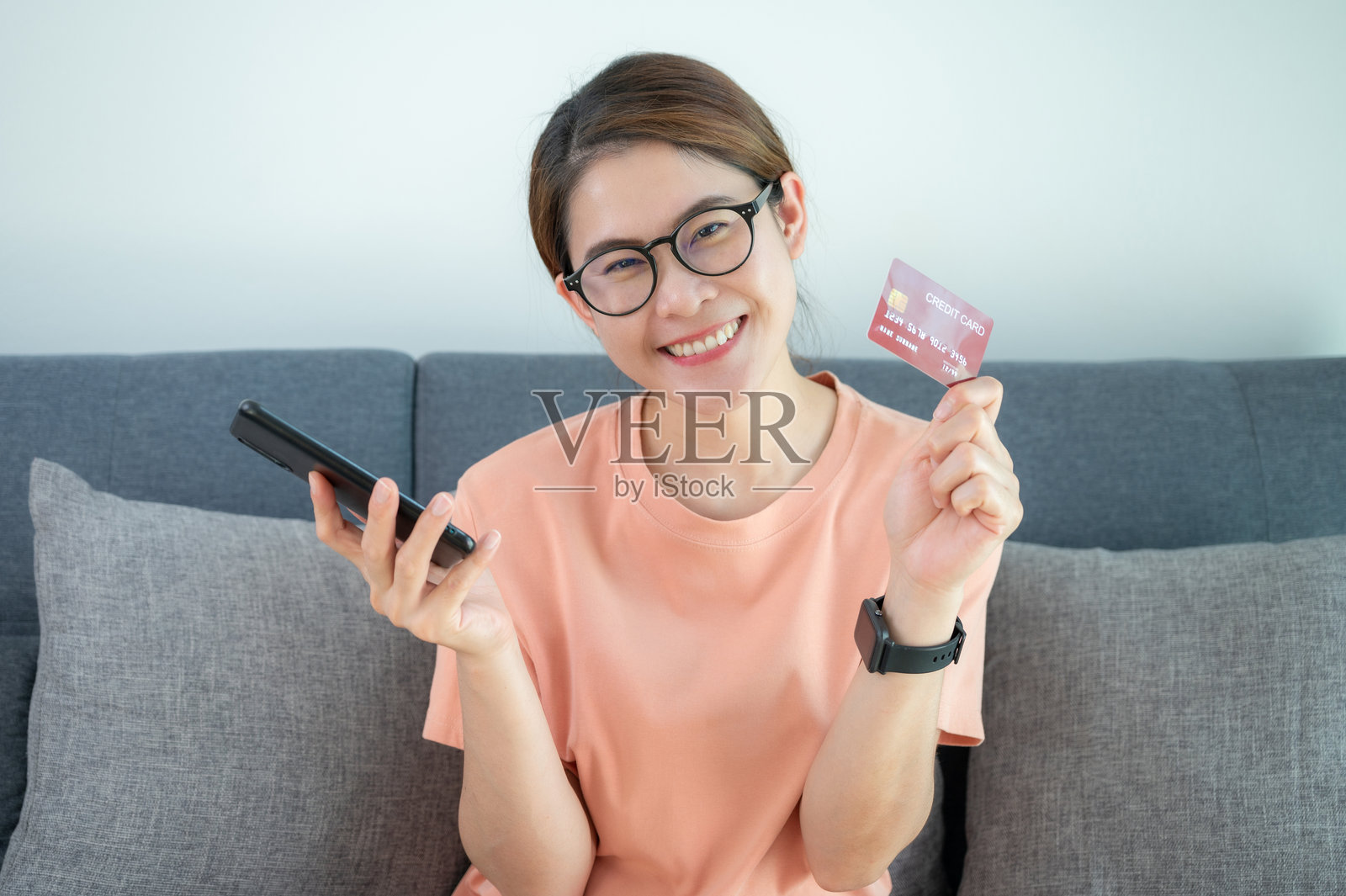 亚洲女性展示她的信用卡。照片摄影图片