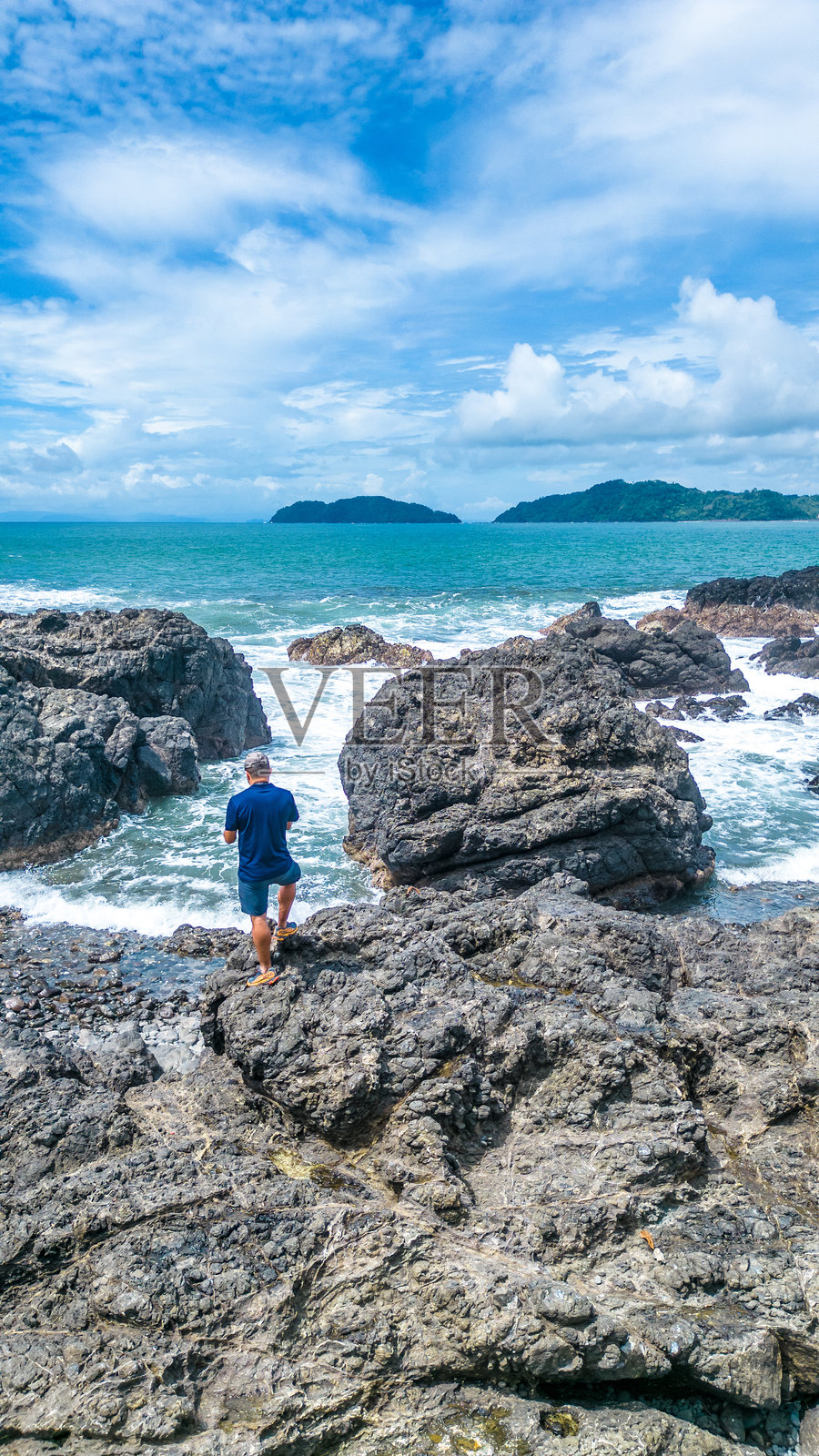 男性游客在哥斯达黎加普恩塔雷纳斯的哈科观景点，阳光明媚的日子里凝视着碧蓝的海洋。照片摄影图片