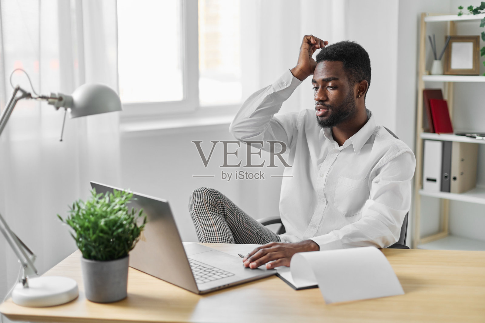 非洲企业家学生在网上自由职业的办公室男士，使用电脑和笔记本电脑进行教育工作。照片摄影图片