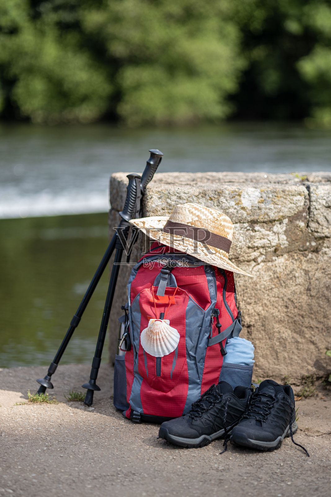 朝圣者前往圣地亚哥·德·孔波斯特拉的背包和其他装备靠在石墙上照片摄影图片