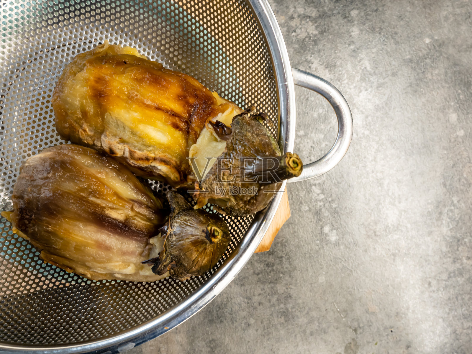 去皮的茄子在炉子上炒制，健康的素食家常菜照片摄影图片